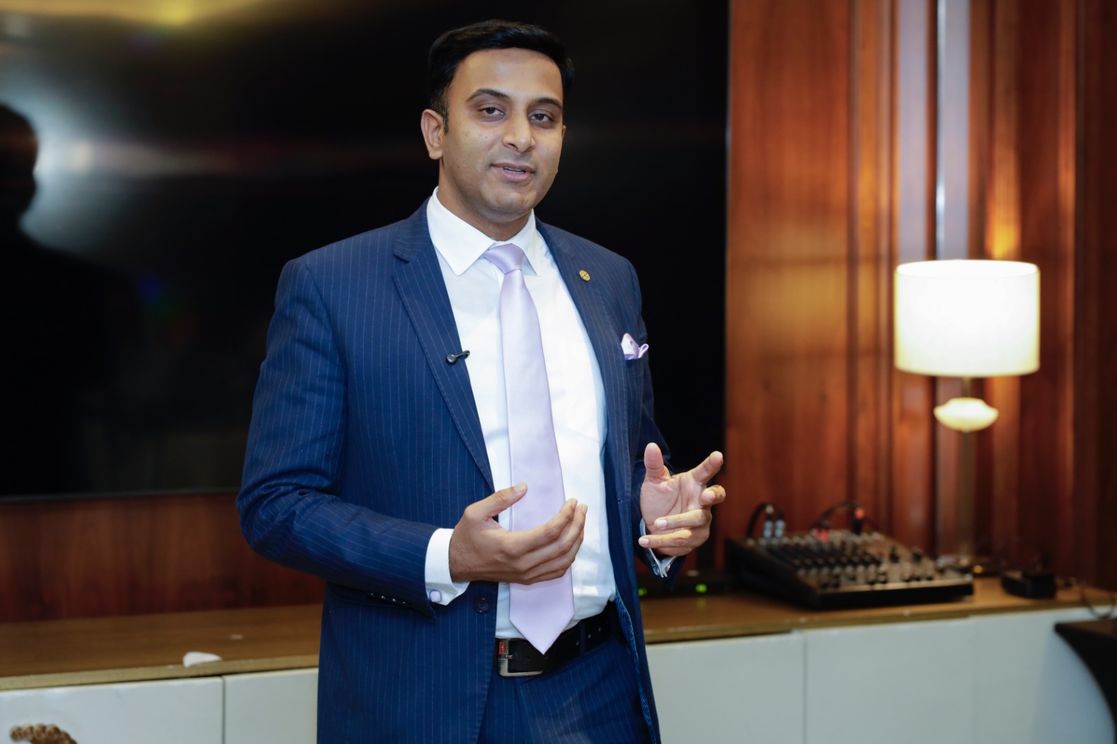 Speaker in a navy suit addressing the room during the masterclass